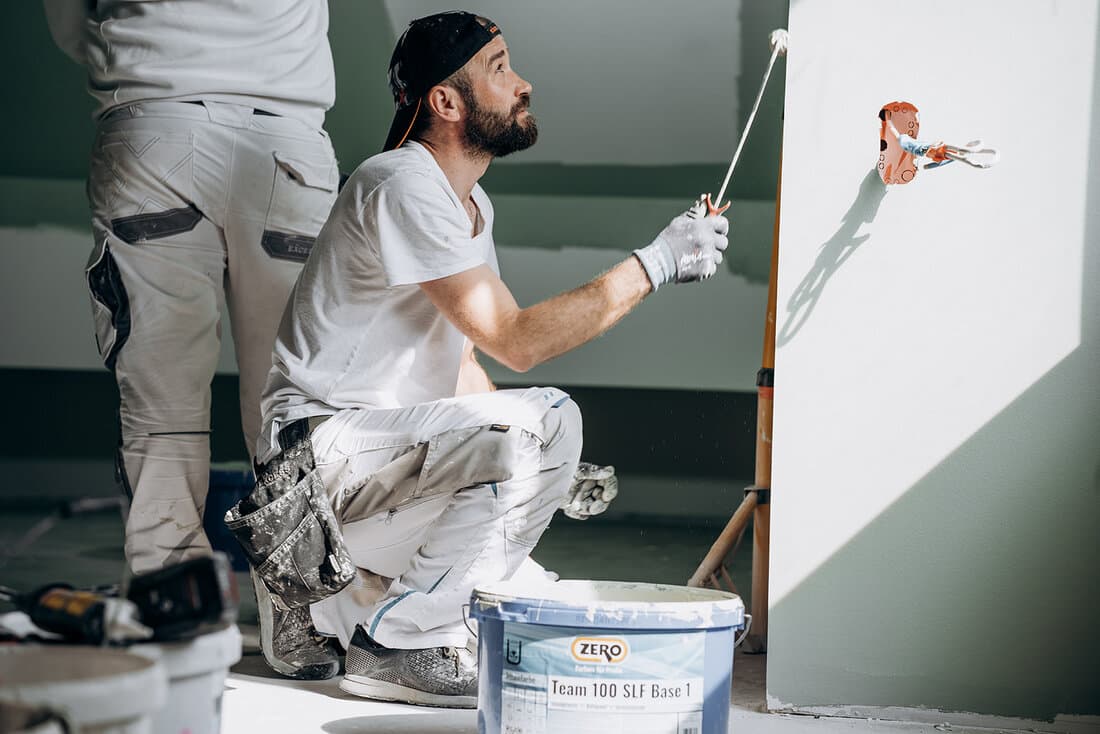 Maler von Raumgestaltung Fuhrmann beim Streichen einer Wand